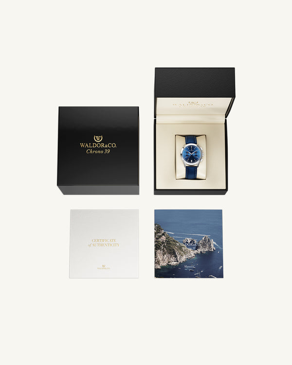 A round mens watch in rhodium-plated silver from Waldor & Co. with blue sunray dial and genuine blue leather strap. A second hand. Seiko movement. The model is Chrono 39 Sardinia 39mm.