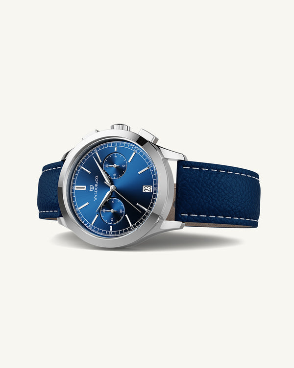 A round mens watch in rhodium-plated silver from Waldor & Co. with blue sunray dial and genuine blue leather strap. A second hand. Seiko movement. The model is Chrono 44 Sardinia 44mm.