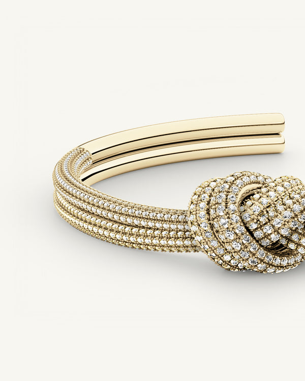 A Bangle in 14k-gold plated copper from Waldor & Co. One size. The model is Dual Knot Bangle Pavè.