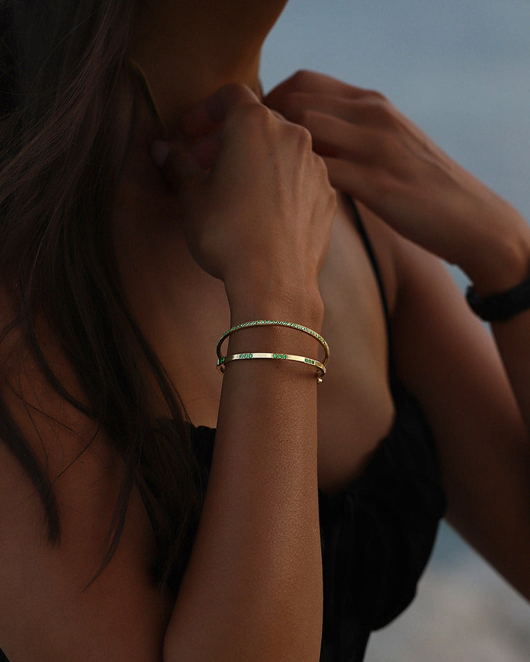  A Bangle in 14k gold-plated 316L stainless steel with green stones from Waldor & Co. One size. The model is Dulcet Bangle Polished.