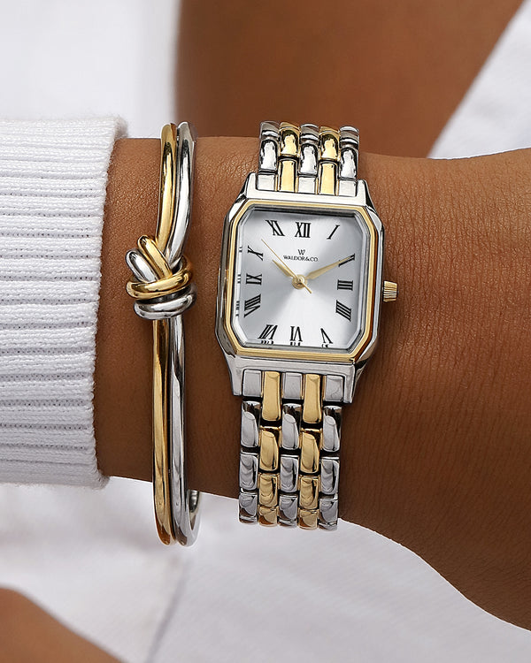 En fyrkantig damklocka i 22k guldpläterat 316L rostfritt stål från WALDOR & CO. med vit Diamond Cut Sapphire Crystal glass urtavla.  Seiko urverk. Modellen är Eternal 22 Bellagio.