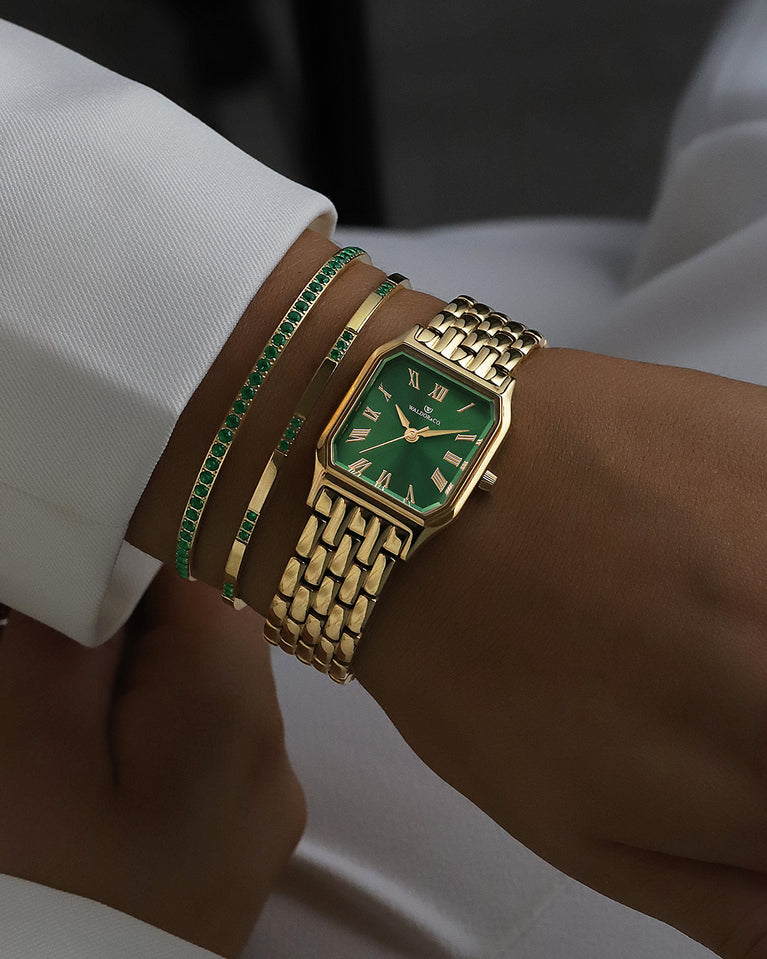 A square womens watch in 22k gold from Waldor & Co. with green Diamond Cut Sapphire Crystal glass dial. Seiko movement. The model is Eternal 22 Bellagio.