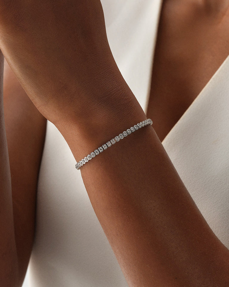 A polished stainless steel bangle in silver from Waldor & Co. One size. The model is Grace Bangle Polished