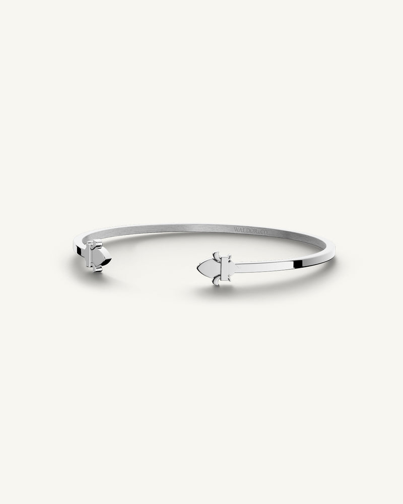 A polished stainless steel bangle in silver from Waldor & Co. One size. The model is Icon Bangle Polished.