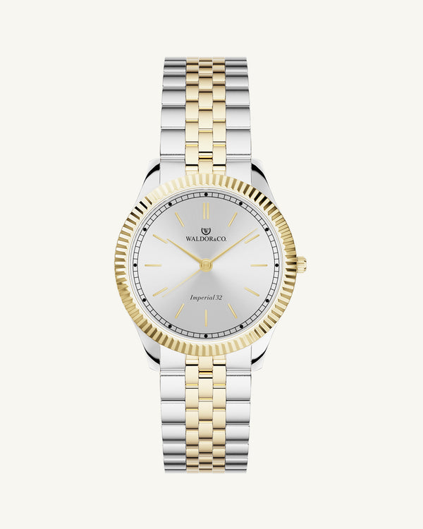 A round womens watch in silver and 22k gold from Waldor & Co. with silver sunray dial and a second hand. Seiko movement. The model is Imperial 32 Positano 32mm.