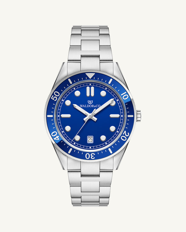 A round mens watch in Rhodium-plated 316L stainless steel from Waldor & Co. with Blue dial in brass with a rotating bezel. Applied indices, luminous hands. Ronda 715. The model is Novel 40 Cap d’Ail 40mm.