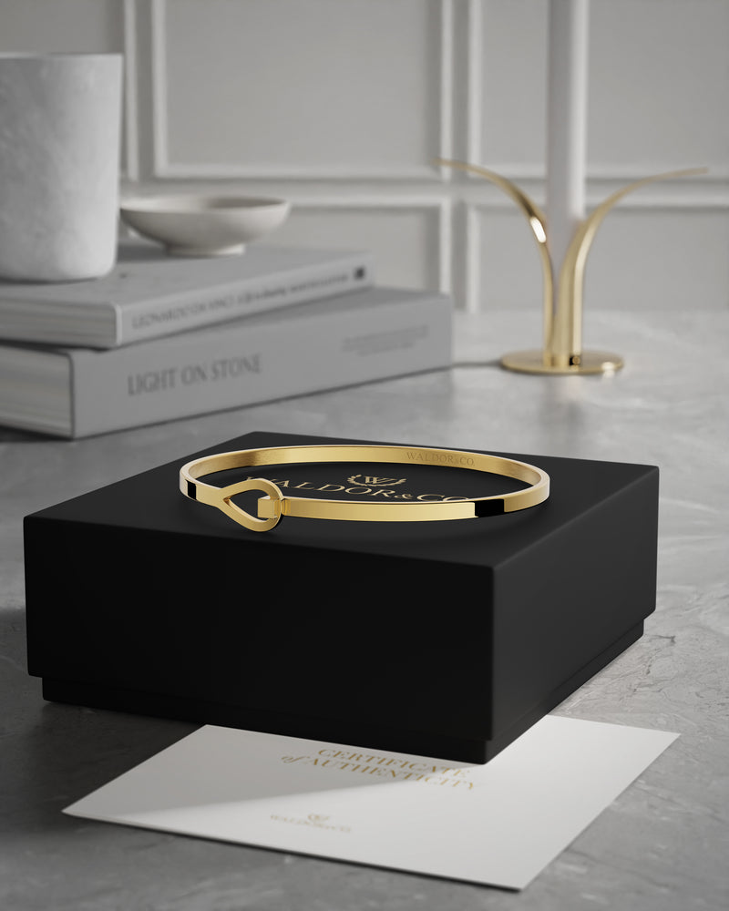 A Bangle in 14k gold plated 316L stainless steel from Waldor & Co. One size. The model is Signature Bangle Polished.