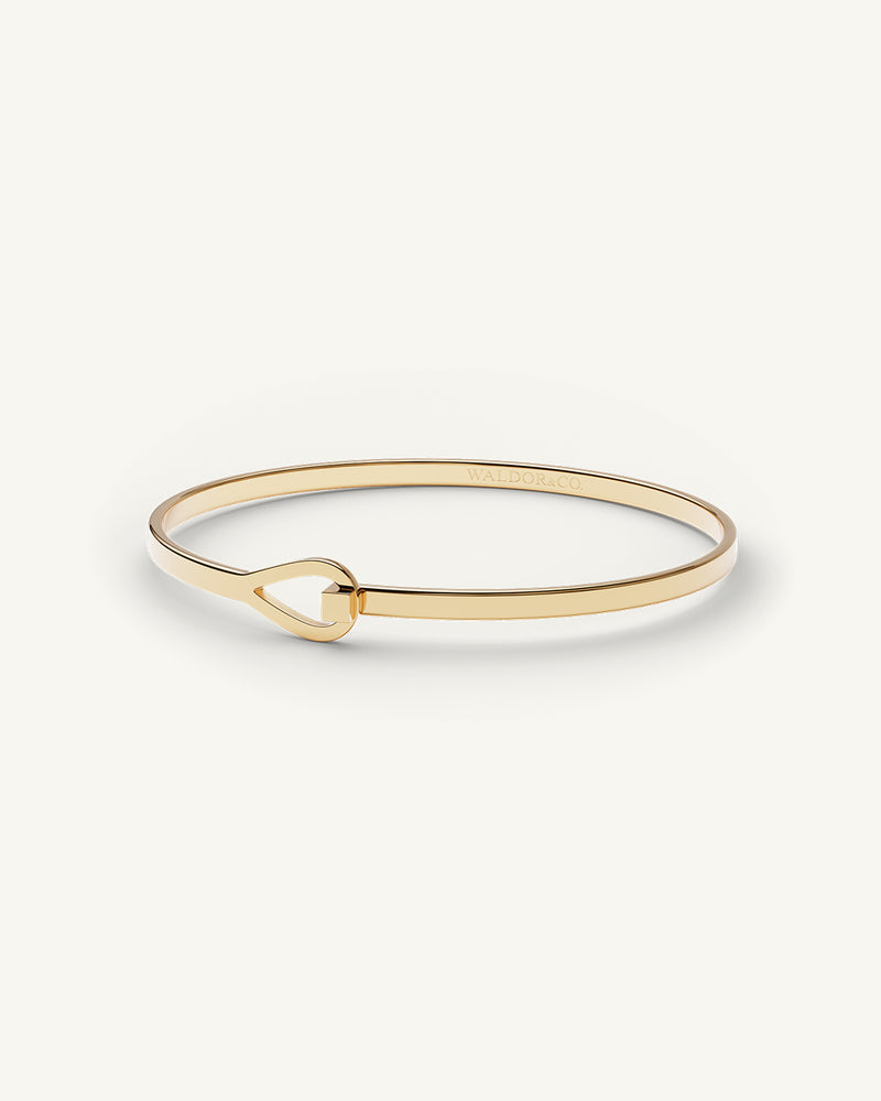 A Bangle in 14k gold plated 316L stainless steel from Waldor & Co. One size. The model is Signature Bangle Polished.