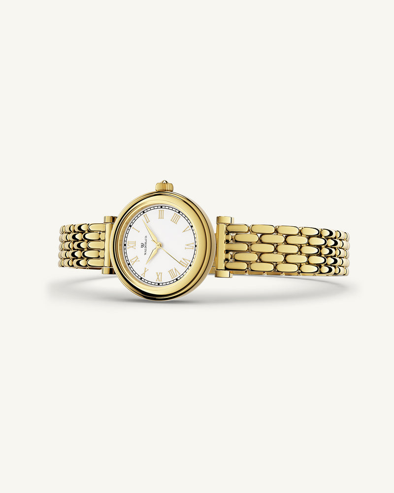 A round womens watch in 22k gold plated 316L stainless steel from Waldor & Co. with white Sapphire Crystal glass dial. Seiko movement. The model is Venia 24 Villefranche.'