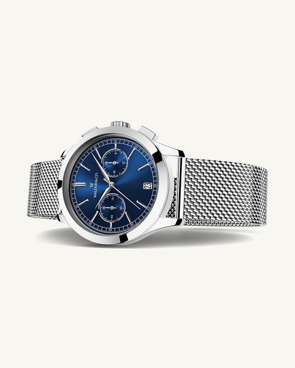 En rund herrklocka i rodiumpläterat silver från WALDOR & CO. med blå sunray urtavla och en sekundvisare. Seiko urverk. Modellen är Chrono 44 Sardinia 44mm. 