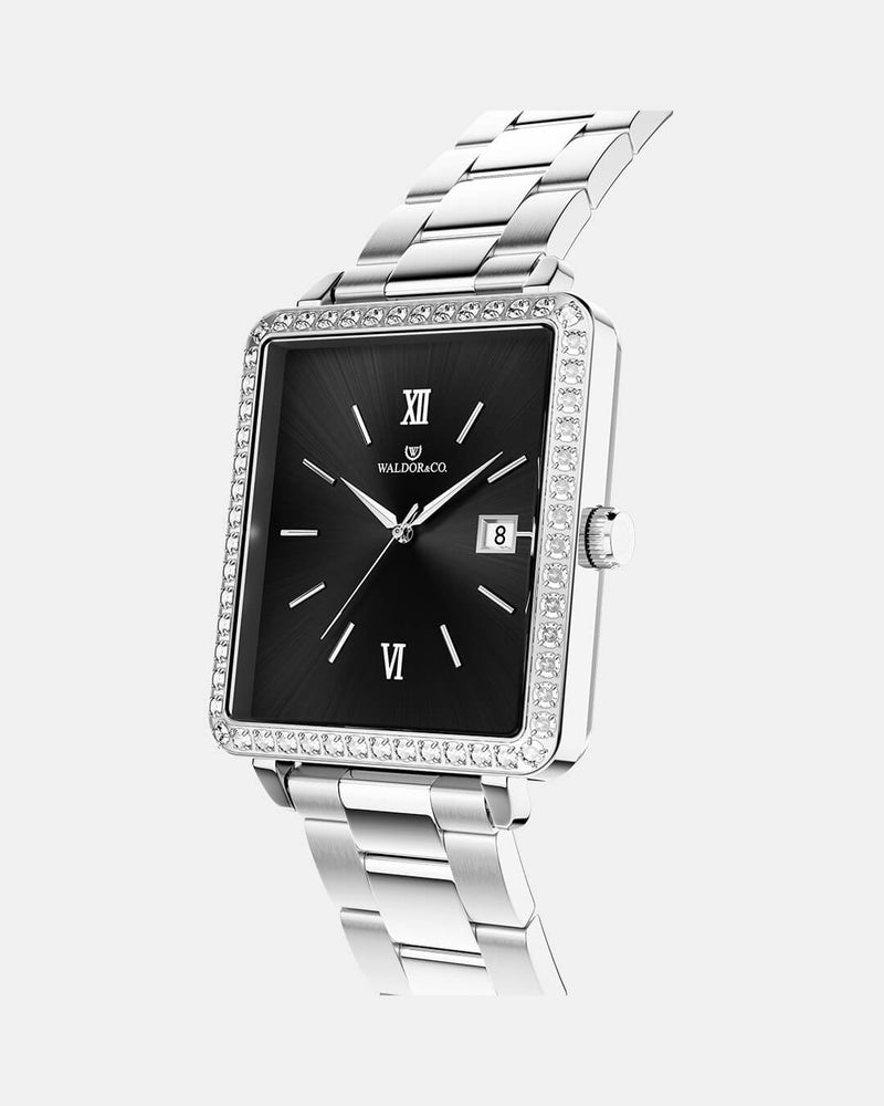  A square womens watch in silver with stones from WALDOR & CO. with black sunray dial and a second hand. Seiko VJ22 movement. The model is Delight 32 Mayfair 28x32mm. 
